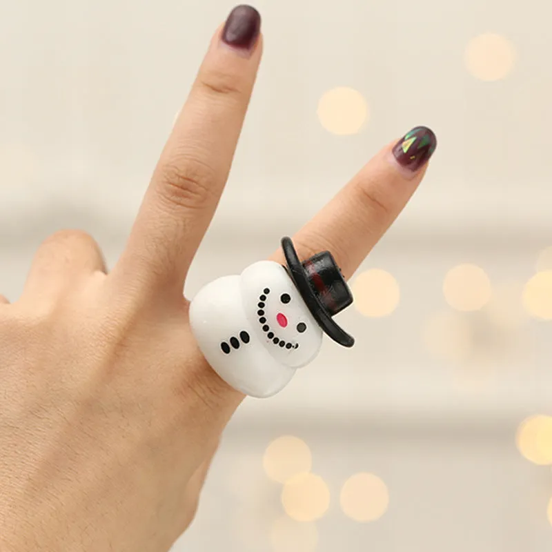 Set of four Christmas party finger lights with designs of small tree, elderly figure, snowflake, and snowman on display