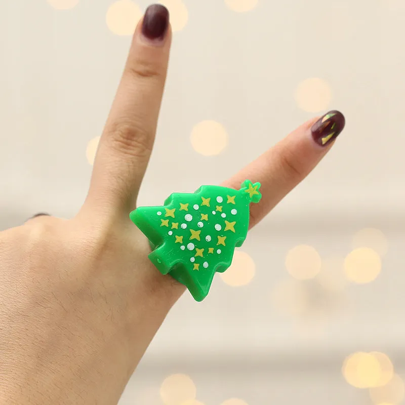 Set of four Christmas party finger lights with designs of small tree, elderly figure, snowflake, and snowman on display