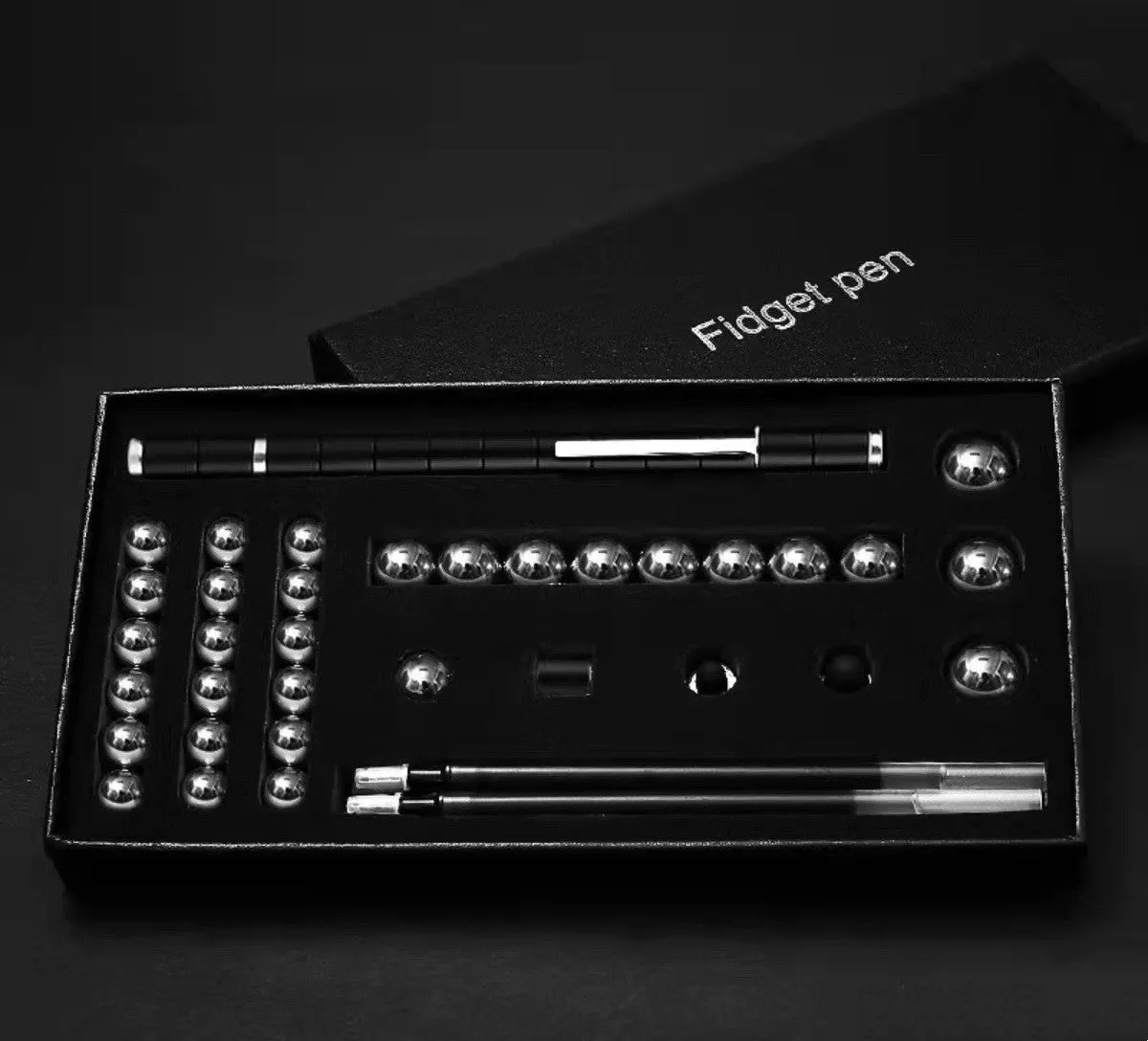 Magnetic modular fidget pen with silver finish, magnetic rings, steel balls, and capacitive head on a table