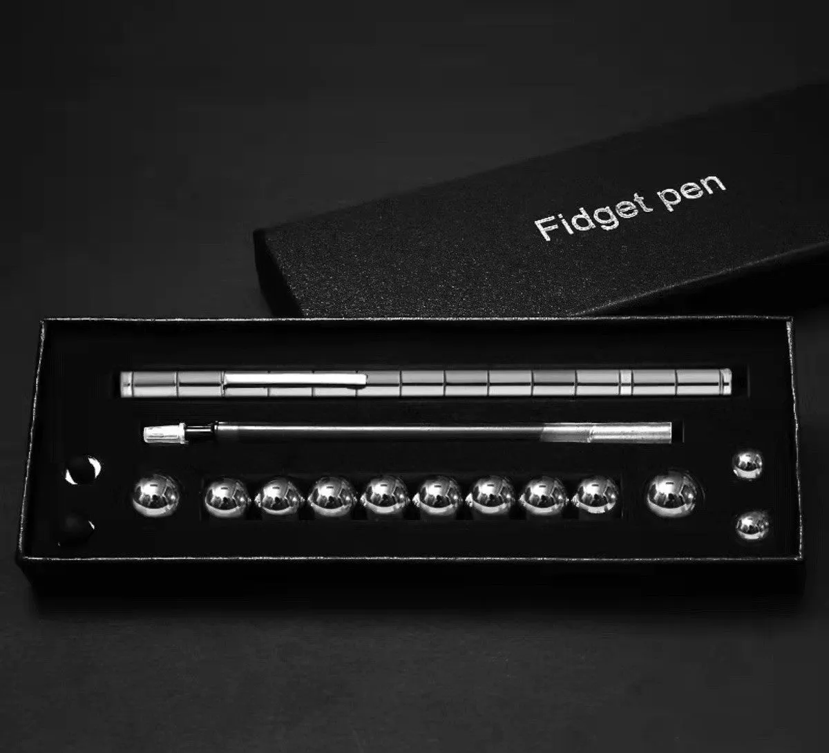 Magnetic modular fidget pen with silver finish, magnetic rings, steel balls, and capacitive head on a table