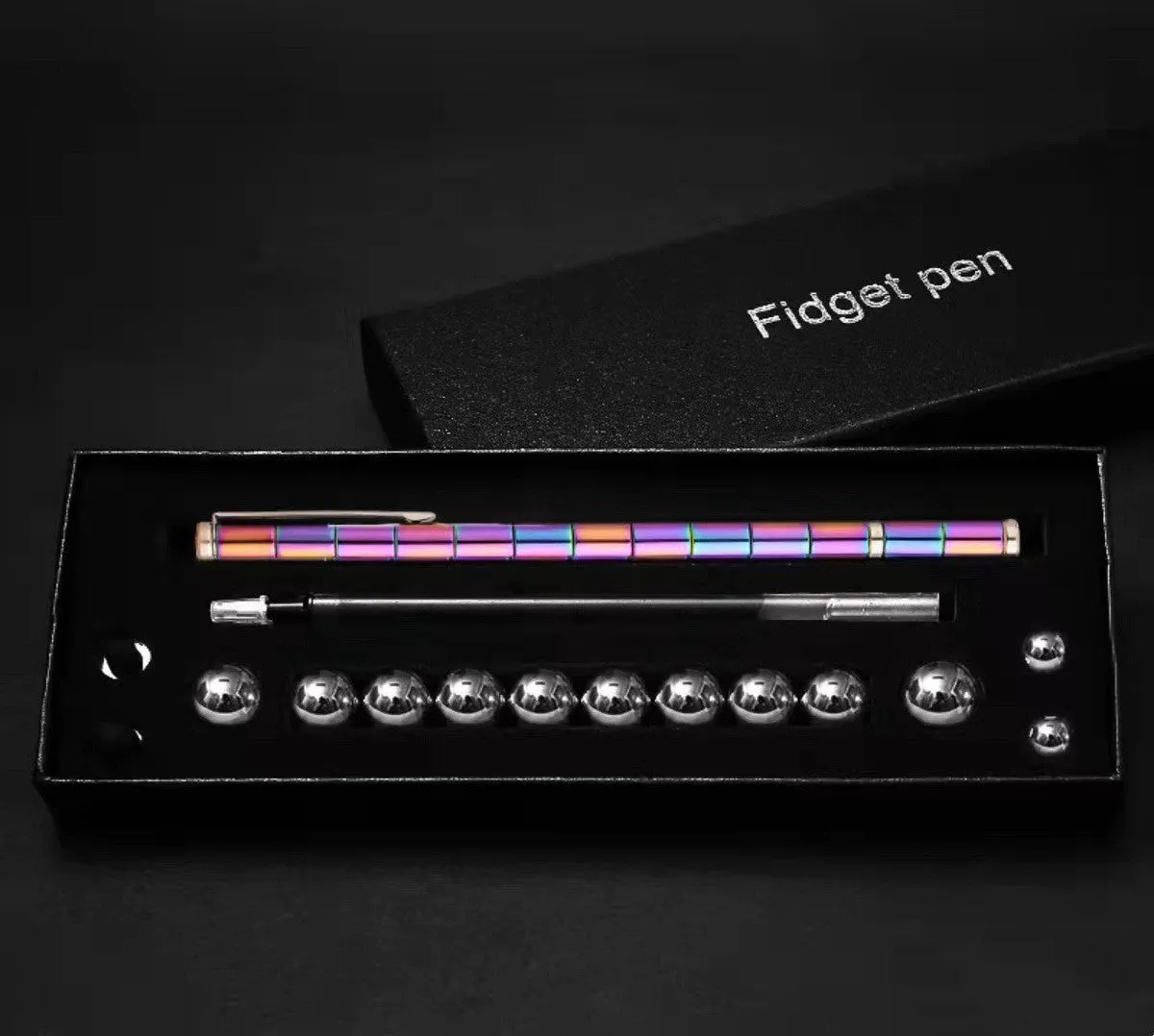 Magnetic modular fidget pen with silver finish, magnetic rings, steel balls, and capacitive head on a table