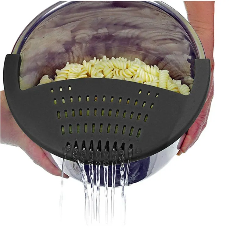 Black silicone food oil drainer snapped onto a pot rim, with liquid being poured off