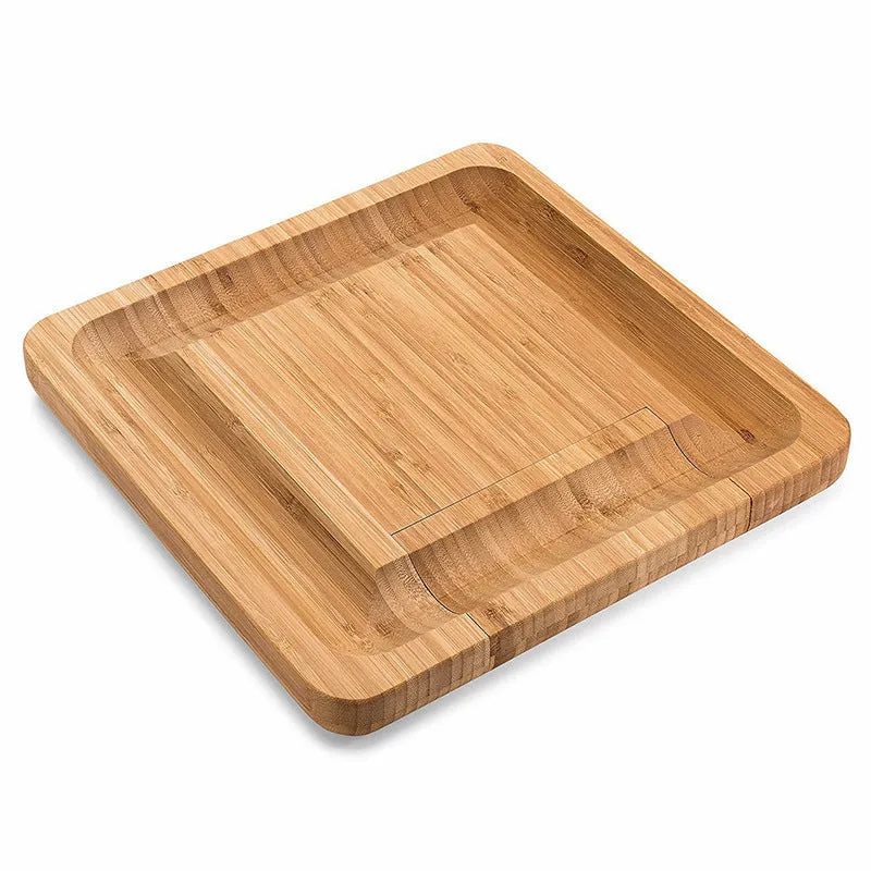 Square bamboo cutting board with drawer holding four-piece knife and fork set in wood colour