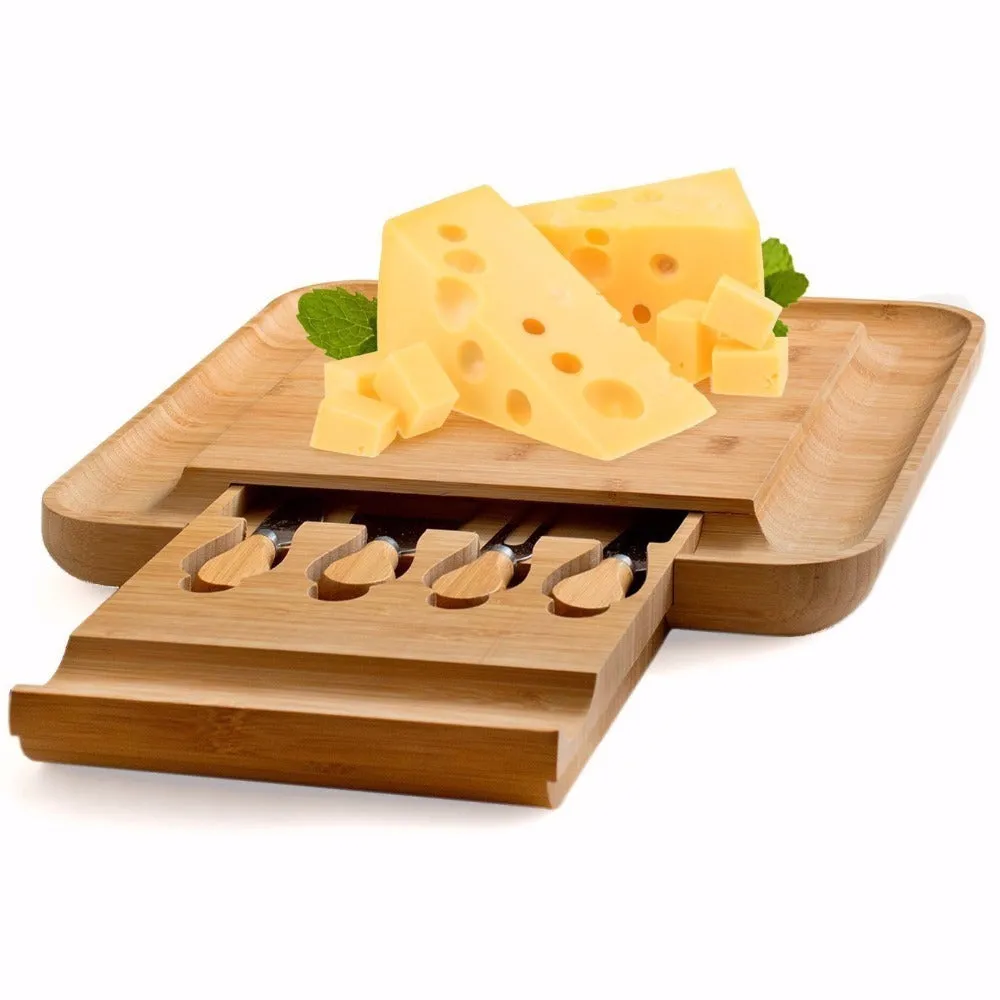 Square bamboo cutting board with drawer holding four-piece knife and fork set in wood colour