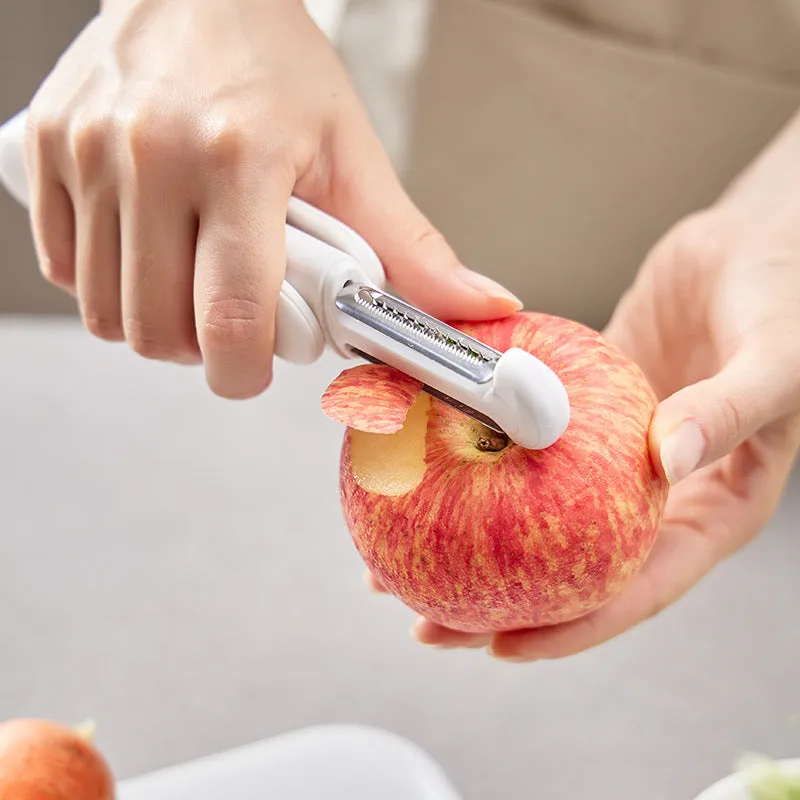 White 3 in 1 rotary paring knife with 360 degree rotating stainless steel blade on a kitchen counter