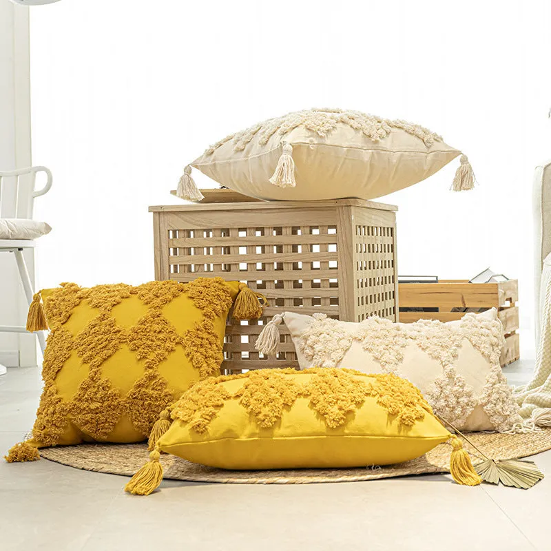 Nordic tufted throw pillow in beige cotton canvas with tassels on a sofa