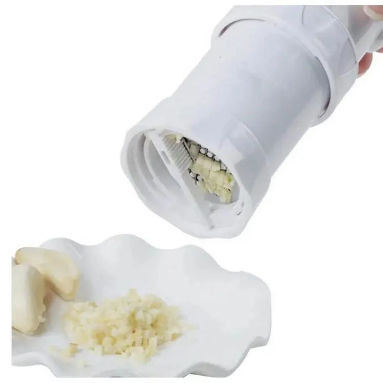 White ABS plastic garlic press with peeler on kitchen countertop