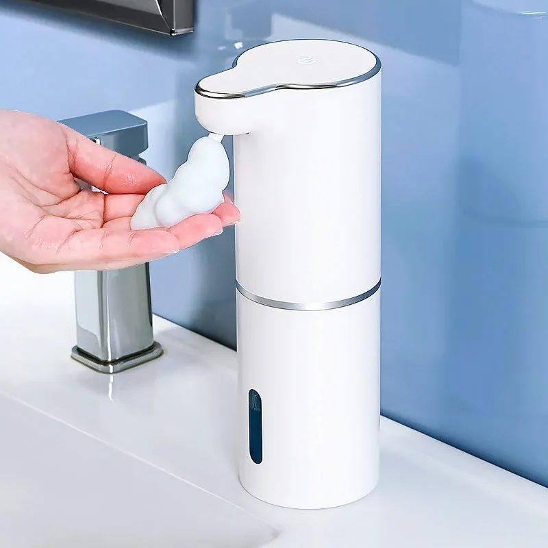White ABS automatic sensor soap dispenser on countertop with USB cable, dispensing foam hand sanitiser.