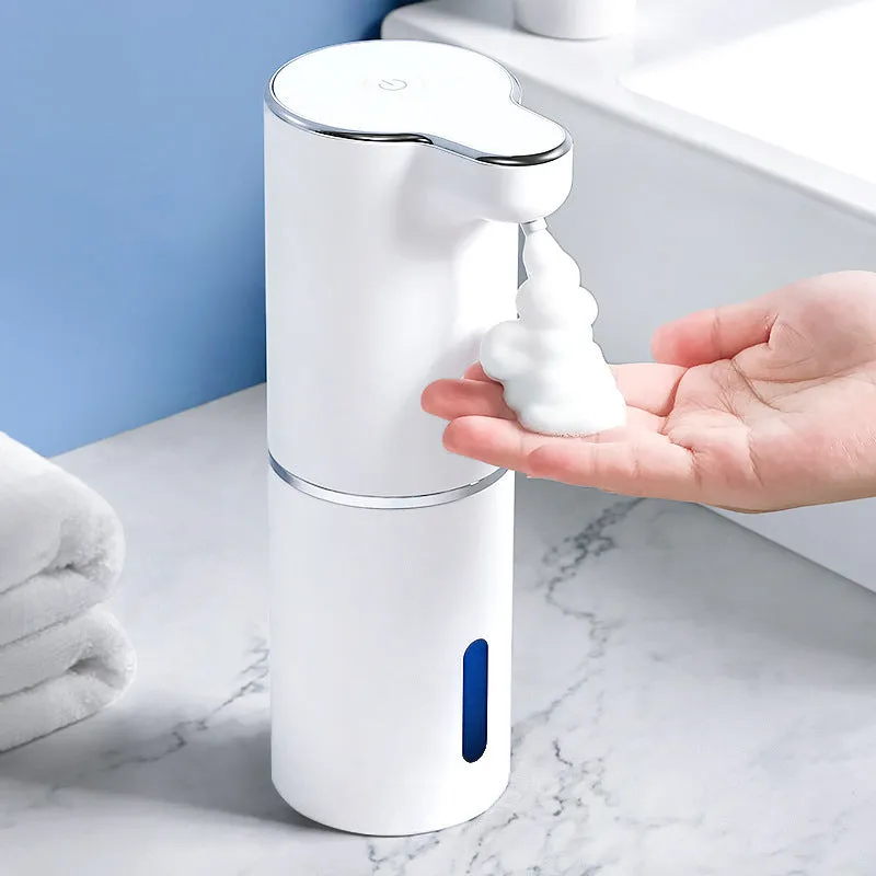 White ABS automatic sensor soap dispenser on countertop with USB cable, dispensing foam hand sanitiser.