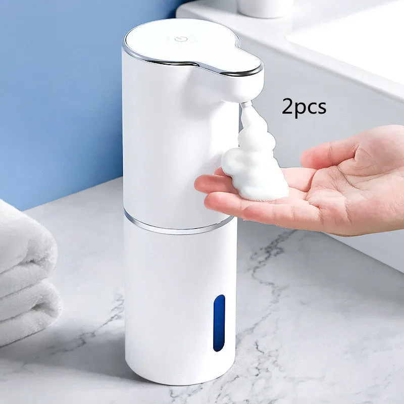 White ABS automatic sensor soap dispenser on countertop with USB cable, dispensing foam hand sanitiser.