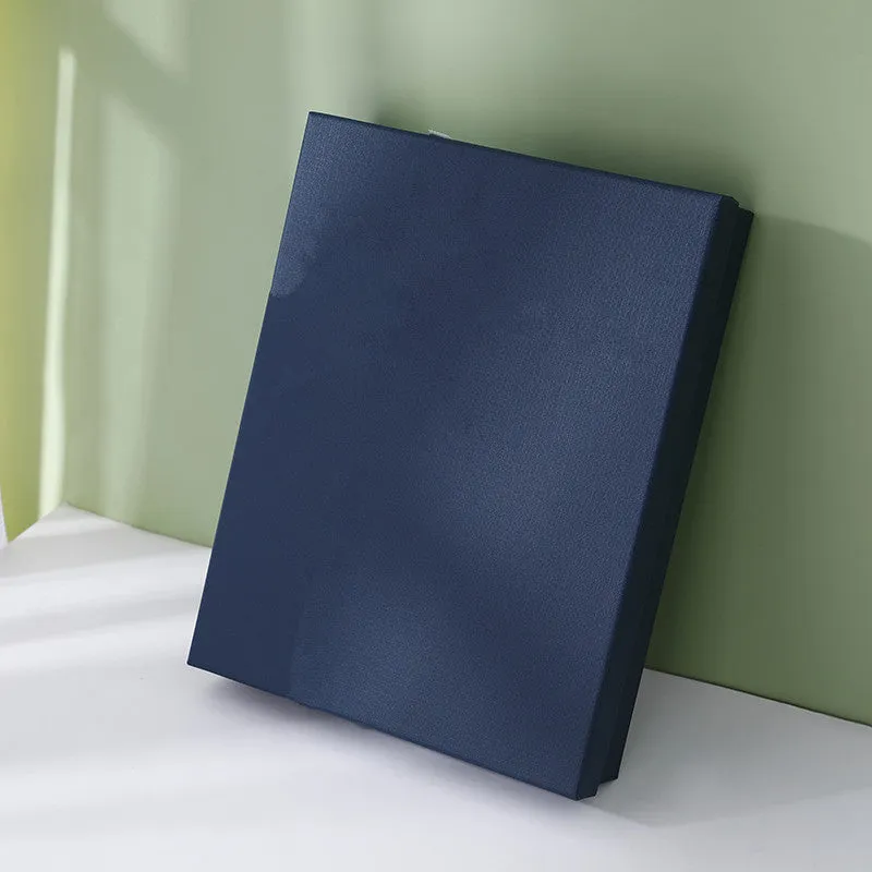 Large blue rectangular cardboard gift box with white base and bow on a plain background
