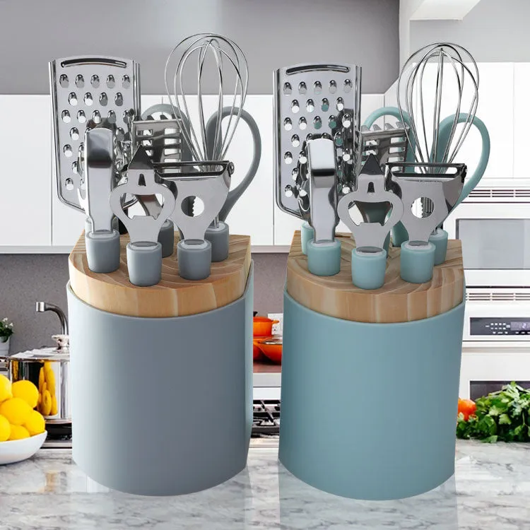 Stainless steel kitchen gadget set with whisk, grater, peeler, fruit knife, scissors, and tray lifter in grey