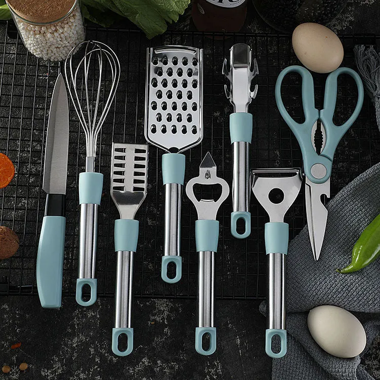 Stainless steel kitchen gadget set with whisk, grater, peeler, fruit knife, scissors, and tray lifter in grey