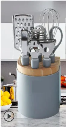 Stainless steel kitchen gadget set with whisk, grater, peeler, fruit knife, scissors, and tray lifter in grey