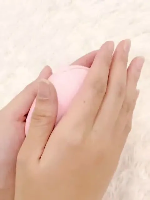 USB hand warmer in pink with three-gear temperature control and compact pebble design