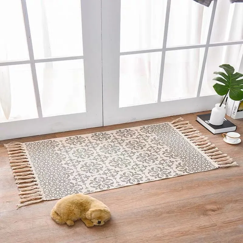 Handwoven cotton linen floor mat 60x90cm in ethnic style with natural plant dye, placed on a wooden floor