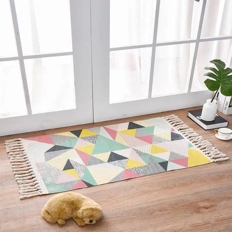 Handwoven cotton linen floor mat 60x90cm in ethnic style with natural plant dye, placed on a wooden floor