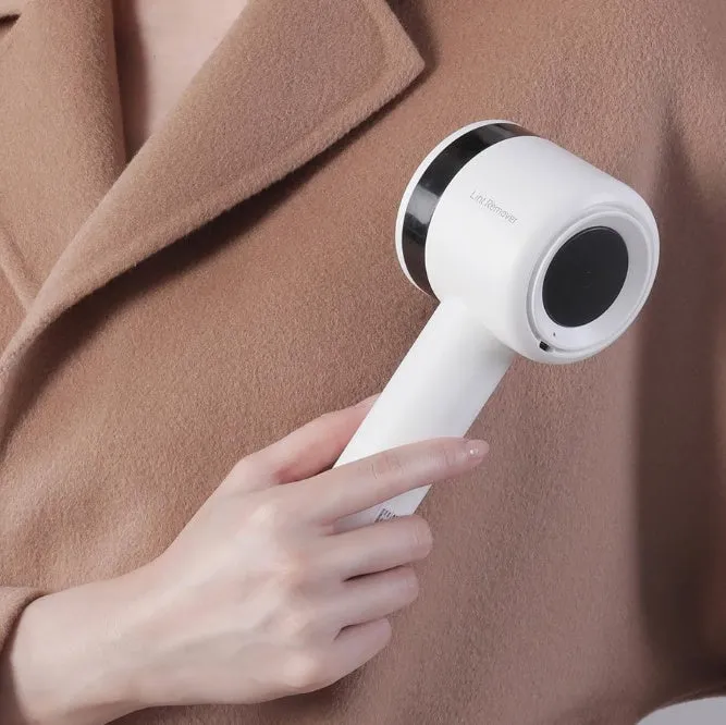 White rechargeable lint remover with hidden hair collection container and detachable three-blade head on white background