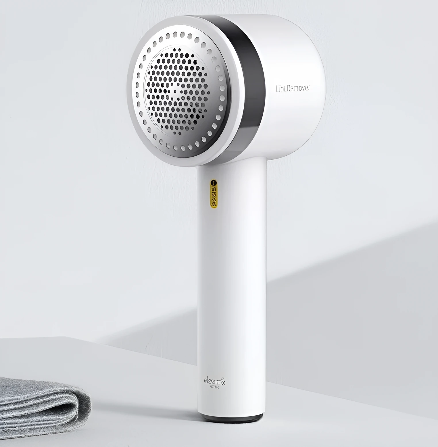 White rechargeable lint remover with hidden hair collection container and detachable three-blade head on white background