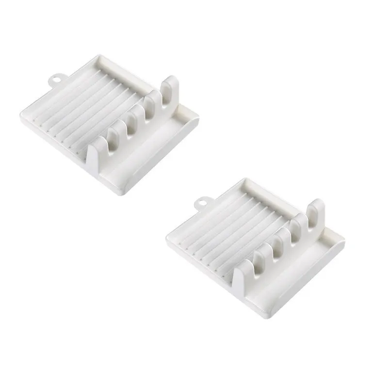 Green silicone kitchen utensil holder with four holes holding spatula, spoon, knife, and chopsticks on countertop