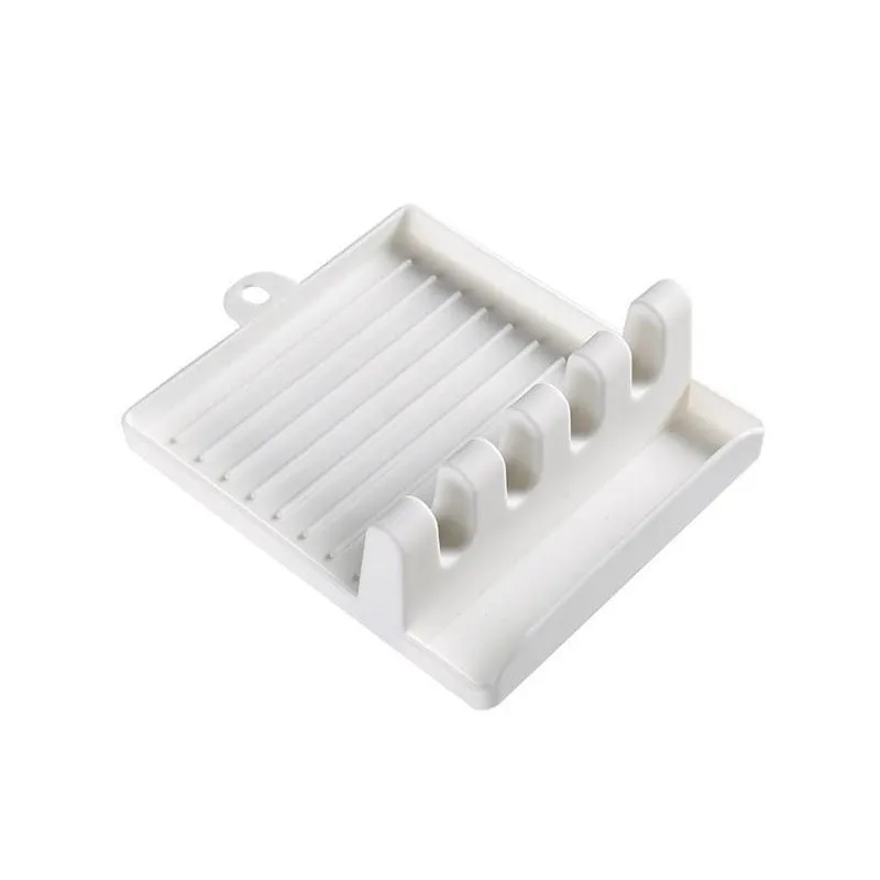 Green silicone kitchen utensil holder with four holes holding spatula, spoon, knife, and chopsticks on countertop