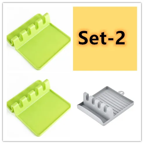 Green silicone kitchen utensil holder with four holes holding spatula, spoon, knife, and chopsticks on countertop