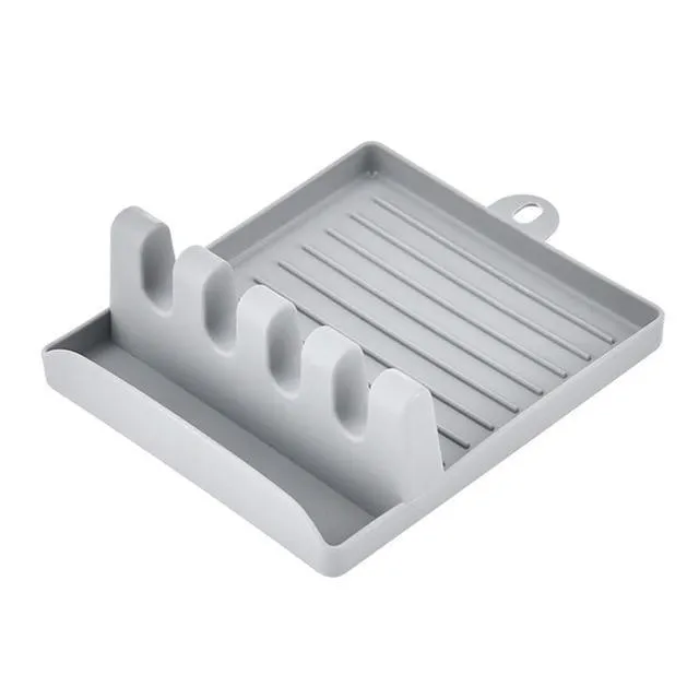 Green silicone kitchen utensil holder with four holes holding spatula, spoon, knife, and chopsticks on countertop