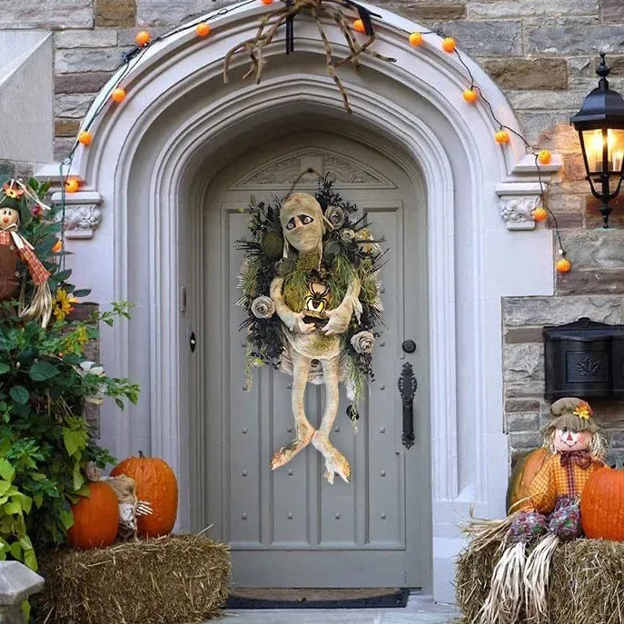Three-dimensional mummy Halloween wreath with skeleton hands on a wooden door