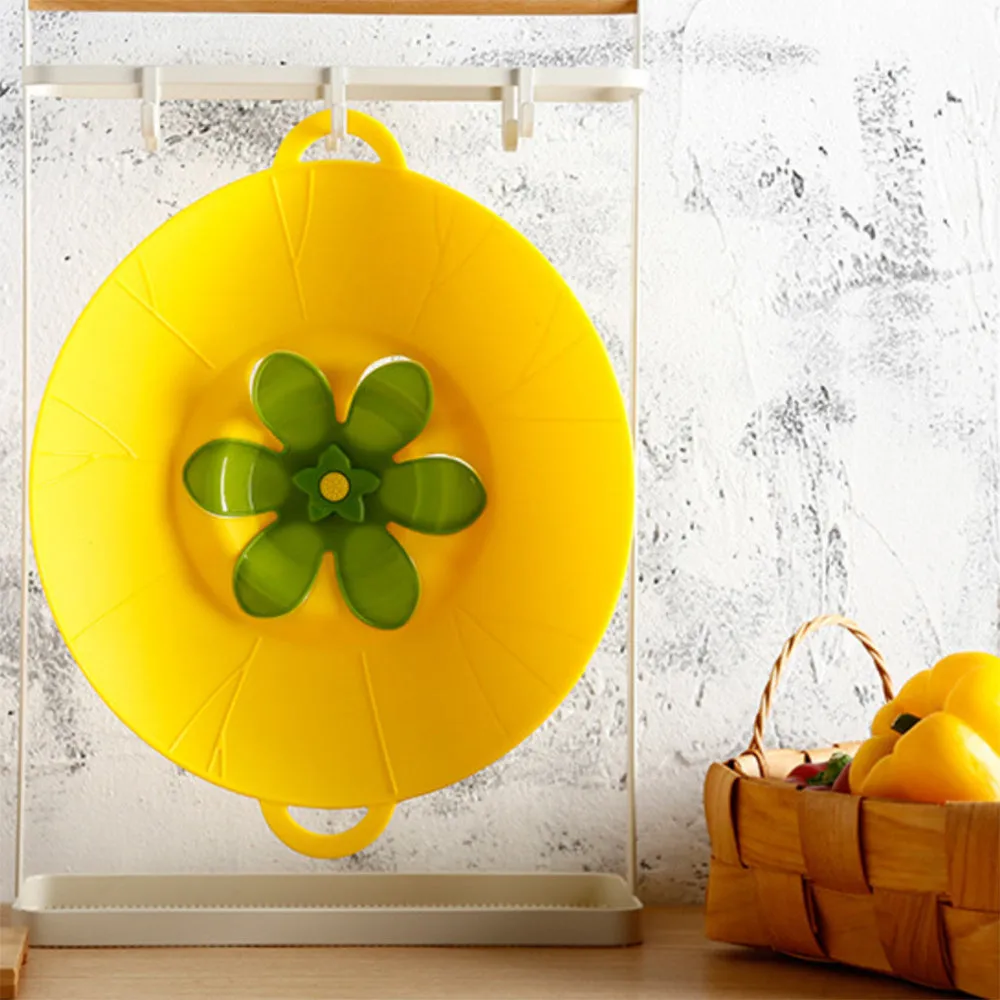 Silicone spill-proof pot cover in black, size 30x26cm, resting on a pot