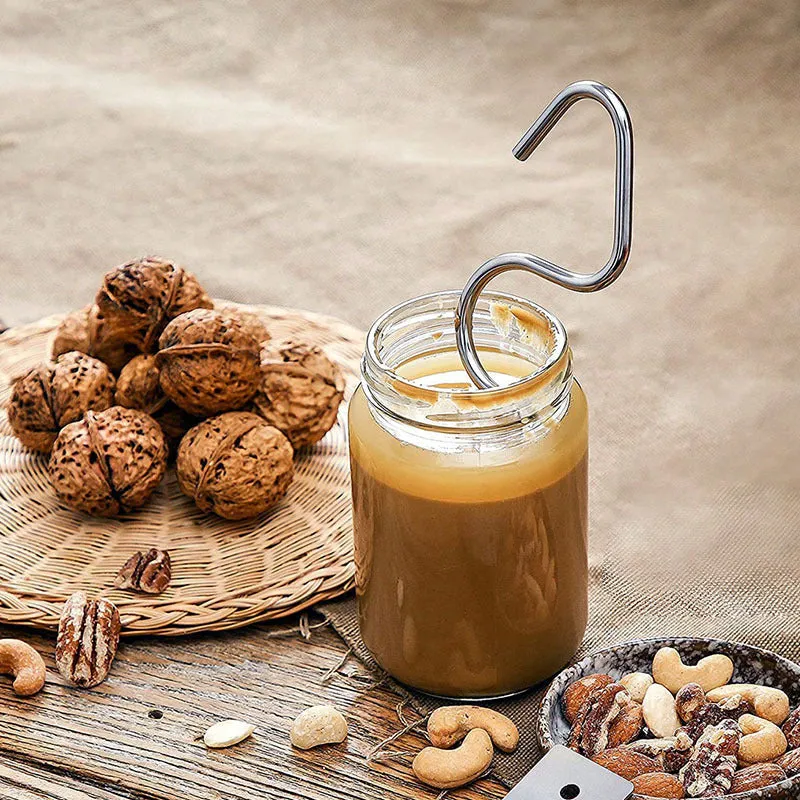 Stainless steel peanut butter mixer stirring rod on a kitchen counter with a jar of peanut butter