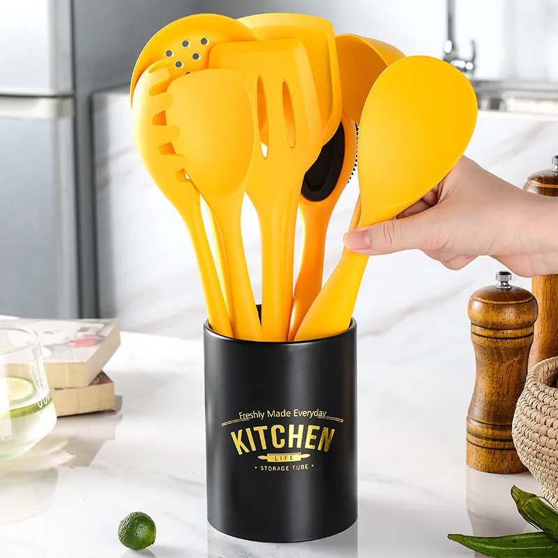 Yellow nonstick silicone and nylon cooking spoon and spatula set on a light background