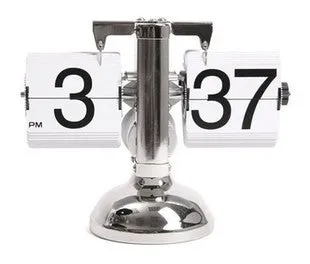 Small scale retro flip clock with black or white trim and black flip cards on a desk