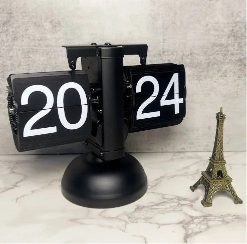 Small scale retro flip clock with black or white trim and black flip cards on a desk