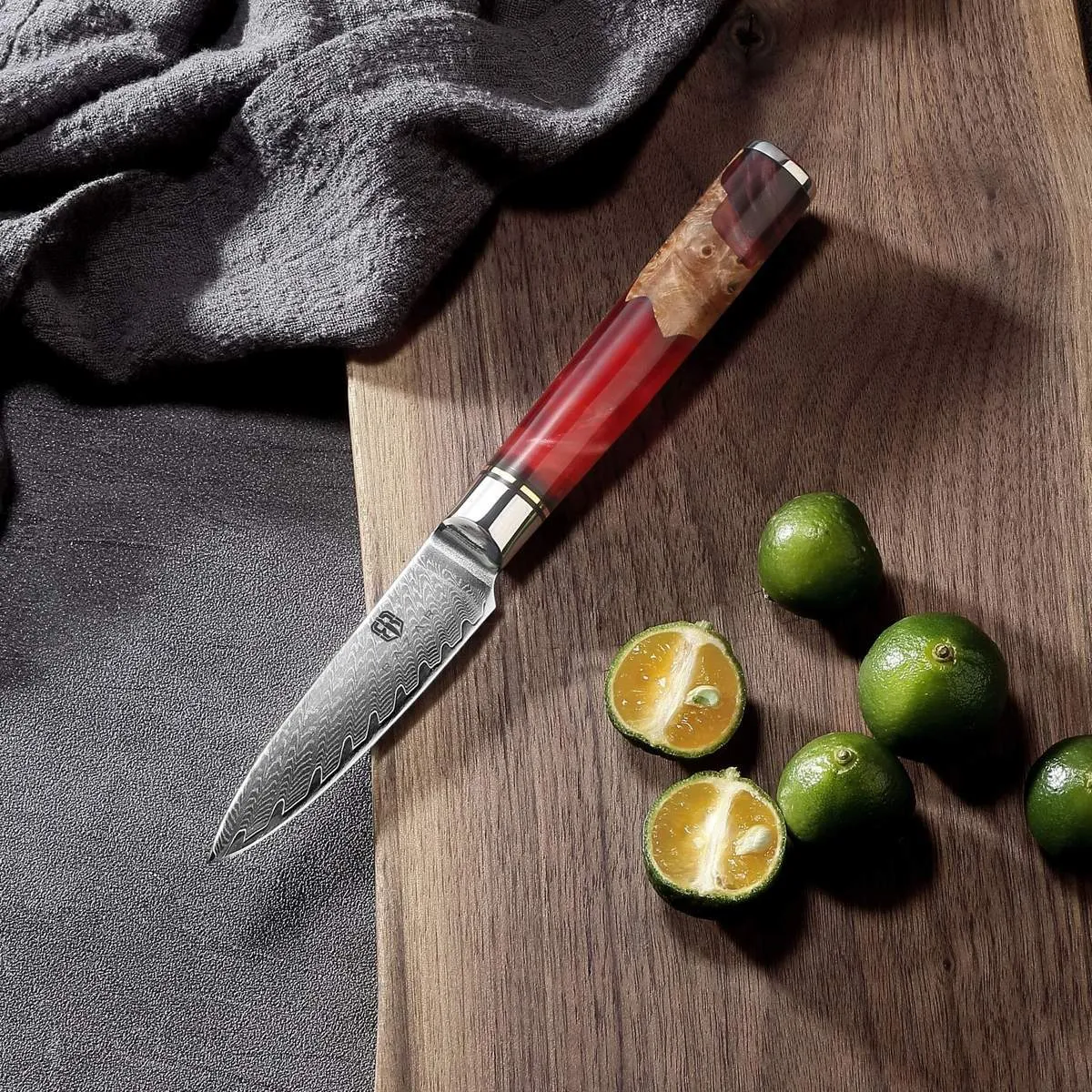 Damascus chef's knife with unique epoxy resin handle and Three German steel blade on cutting board