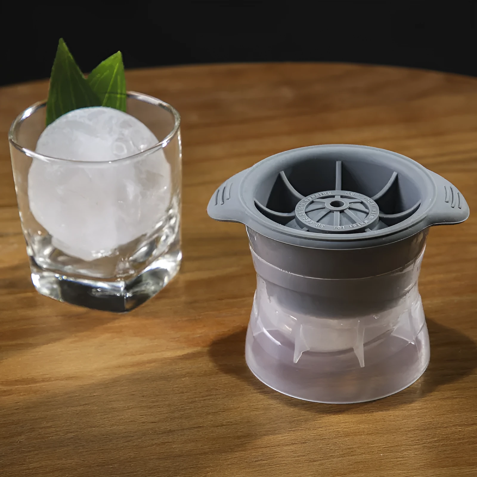 Gray silicone spherical ice ball mould with ABS lid on a kitchen countertop