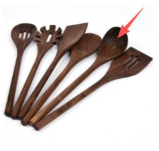 Black walnut 6-piece wooden kitchen utensil set with spatula, spoons, and spaghetti claws on a table