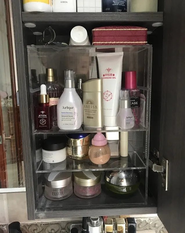 Clear acrylic cosmetics storage box 24x10x34cm on a vanity table holding makeup and skincare products