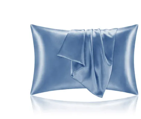Dark blue polyester satin pillowcase with envelope closure on a bed with white sheets