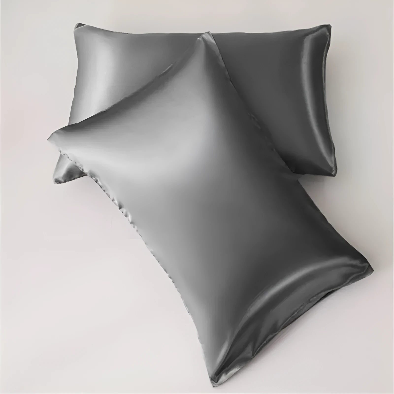 Dark blue polyester satin pillowcase with envelope closure on a bed with white sheets