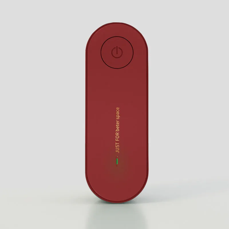 Small negative ion air purifier in black, plugged into a wall socket, with a room in the background
