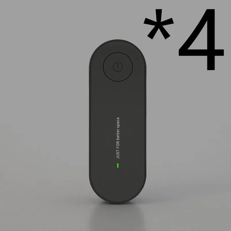 Small negative ion air purifier in black, plugged into a wall socket, with a room in the background