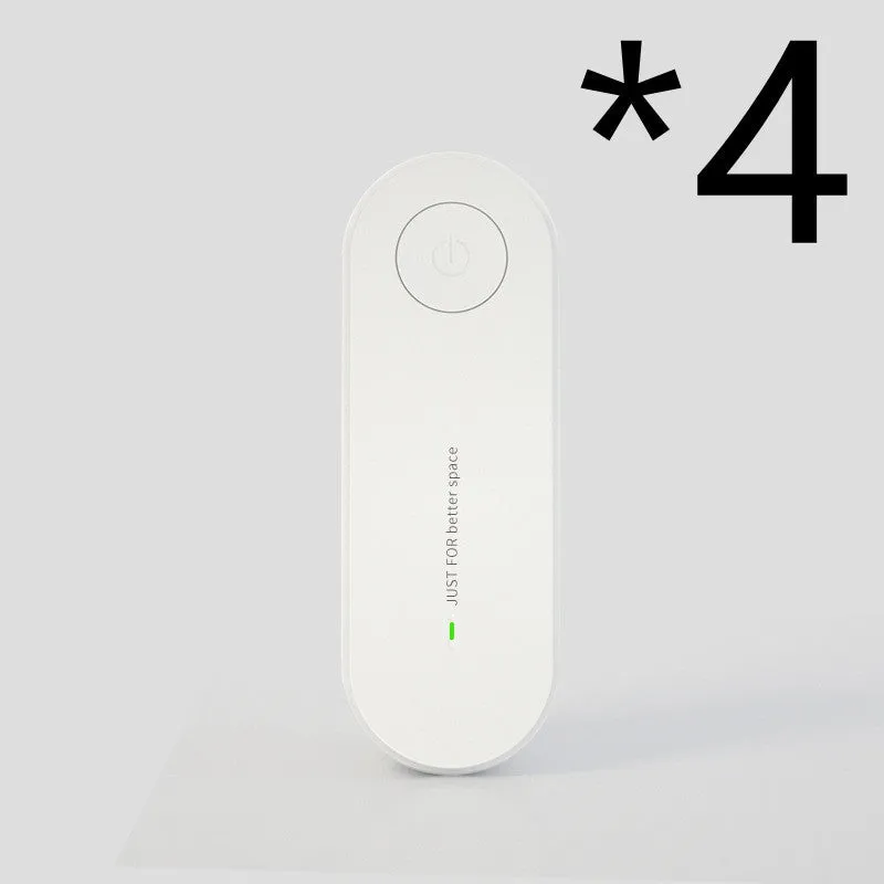Small negative ion air purifier in black, plugged into a wall socket, with a room in the background