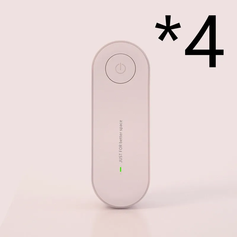 Small negative ion air purifier in black, plugged into a wall socket, with a room in the background