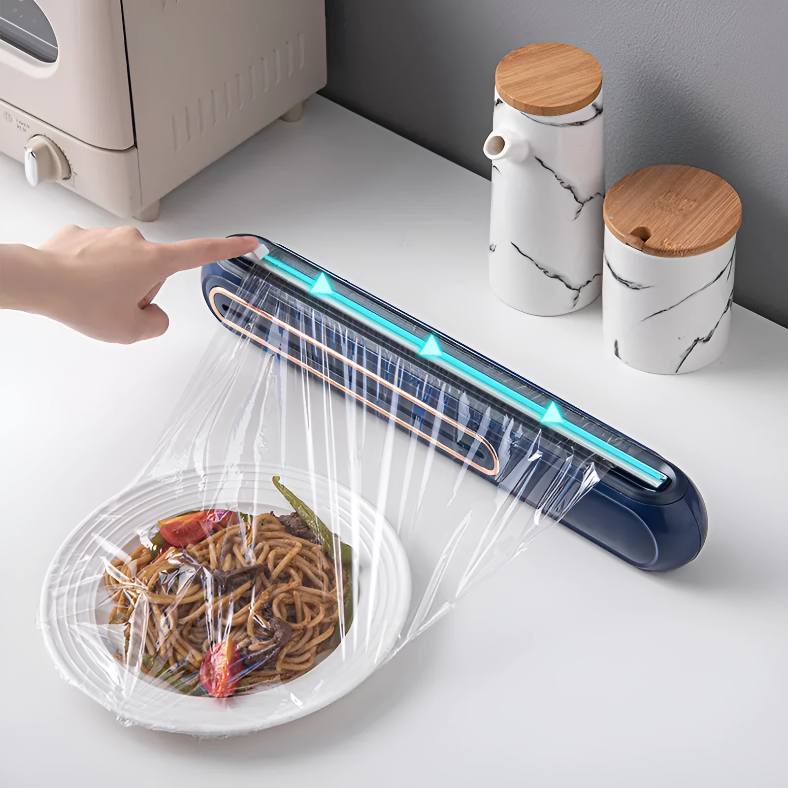 White and blue magnetic cling film cutter hanging on a fridge with a film roll