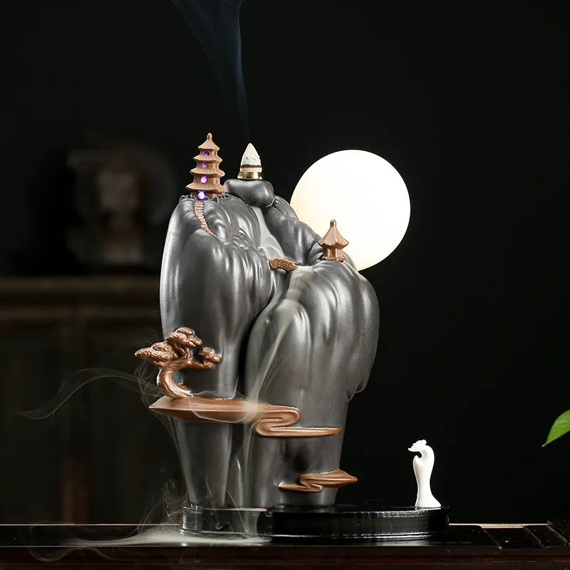 Purple sand tea pet with backflow incense and LED light in Jinglian Tianxiang style on a wooden table