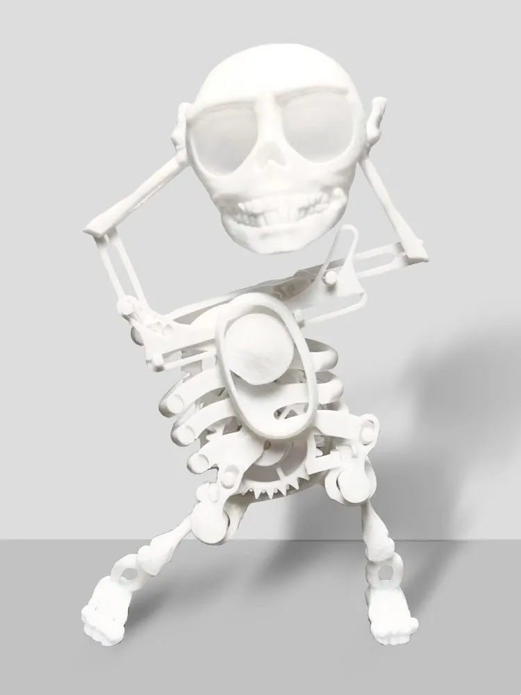 3D printed dancing skeleton gravity toy in pink and white, 22cm tall, on a desk