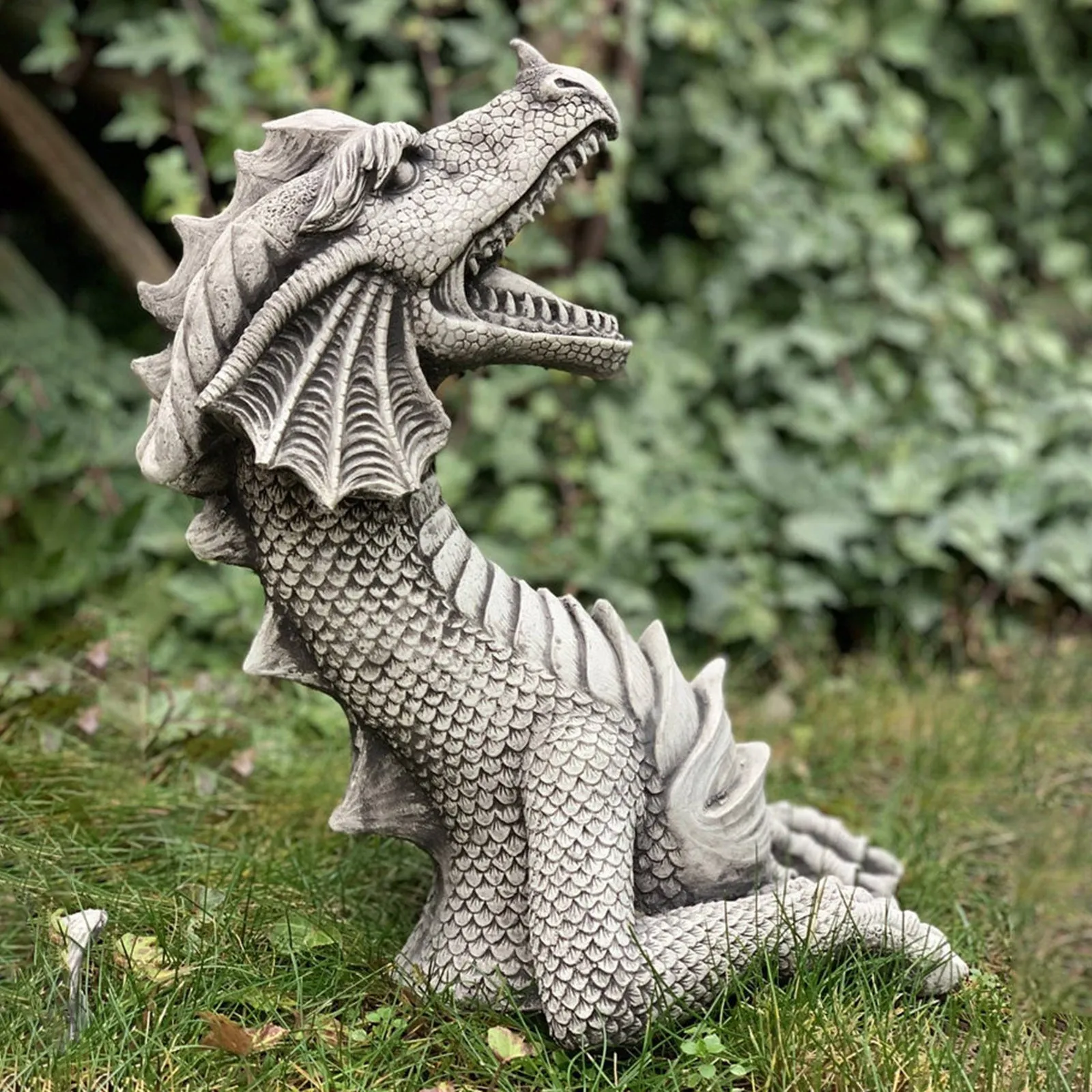 Large gothic dragon garden statue in charcoal grey resin with wings and tail, placed on a lawn