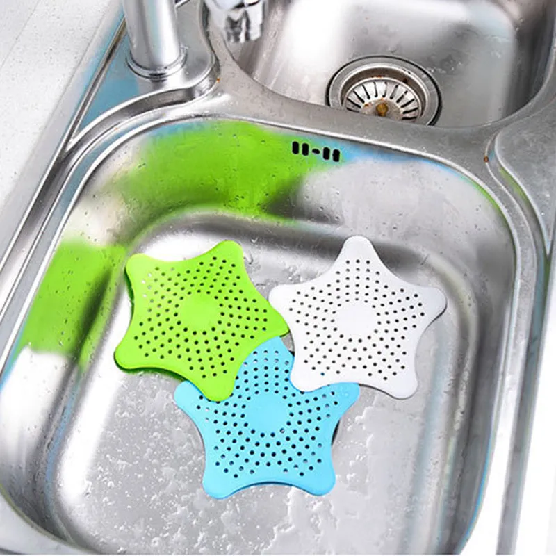 Three silicone starfish sink drain strainers in white, blue, and green with suction cups on bottom