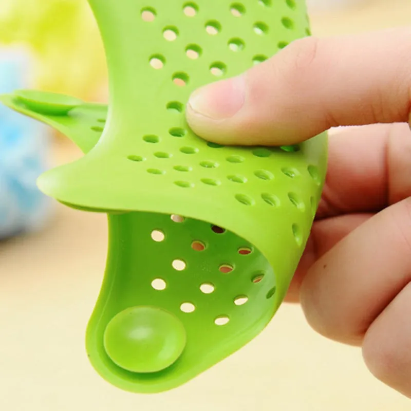 Three silicone starfish sink drain strainers in white, blue, and green with suction cups on bottom