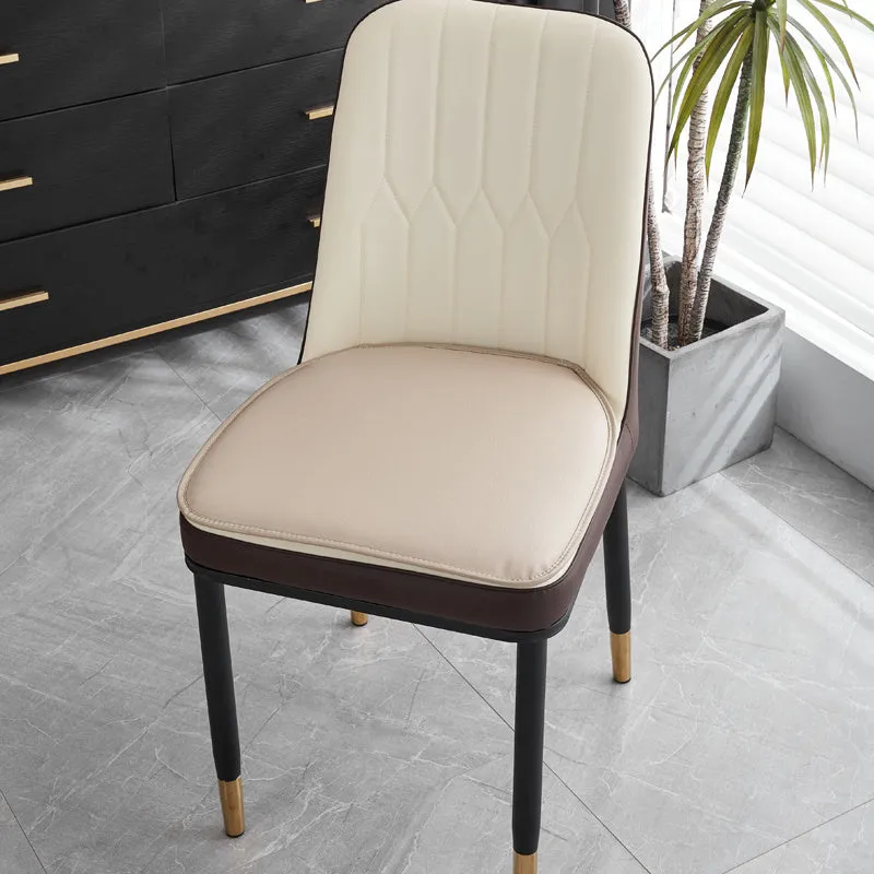 Orange leather horseshoe-shaped seat cushion on a wooden dining chair.